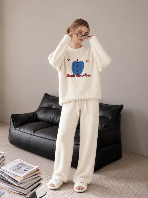 Cream plush fleece pajama set with a blue fruit motif, burgundy lettering, ribbed neckline and sleeve cuffs, and matching full-length drawstring pants.