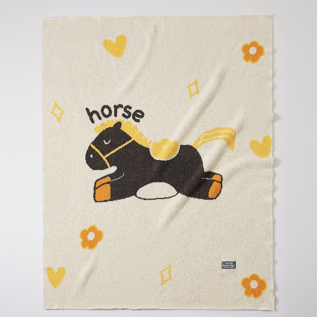 Off-white Half Fleece Knitted Throw Blanket with Cartoon Trojan Horse Pattern, Full Draped View
