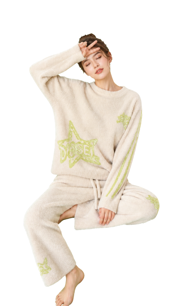 Model wearing a cream fleece pajama set with lime-green star motifs.