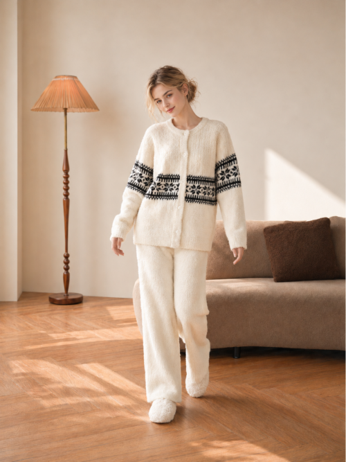 Woman wearing a cream half fleece button-front cardigan pajama set with dark Fair Isle bands, full-body view