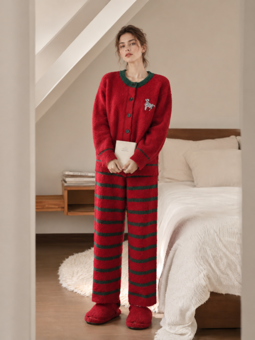 Full-body view of a woman wearing red and green zebra fleece cardigan pajamas
